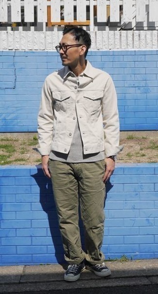 Модный лук: белая джинсовая куртка, серая футболка с круглым вырезом, оливковые брюки чинос, темно-сине-белые низкие кеды из плотной ткани