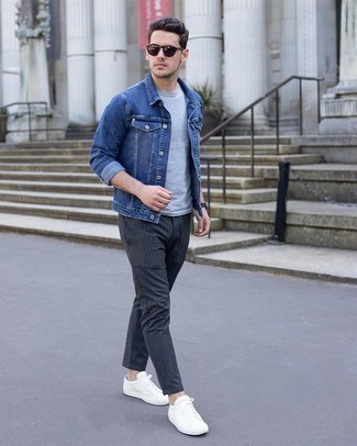 С чем носить синюю джинсовую куртку в 20 лет мужчине в стиле кэжуал: Синяя джинсовая куртка и темно-серые брюки чинос в вертикальную полоску — обязательные вещи в арсенале стильного мужчины. Что же до обуви, белые низкие кеды из плотной ткани — наиболее подходящий вариант.