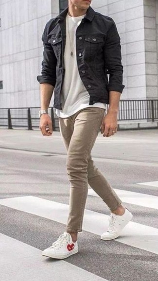 С чем носить обувь с принтом мужчине в теплую погоду: Тандем темно-серой джинсовой куртки и светло-коричневых джинсов поможет подчеркнуть твою индивидуальность. Пара белых низких кед из плотной ткани с принтом свяжет образ воедино.