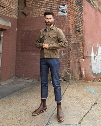 С чем носить коричневую джинсовую куртку мужчине осень в стиле смарт-кэжуал: Коричневая джинсовая куртка и темно-синие джинсы прочно закрепились в гардеробе современных джентльменов, позволяя составлять сногсшибательные и комфортные луки. И почему бы не добавить в повседневный ансамбль толику консерватизма с помощью темно-коричневых кожаных ботинок челси? Держи подобный лук про запас, когда осенью погода станет менее благоприятной.