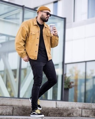 Какие зауженные джинсы носить с черными низкими кедами в 30 лет мужчине в теплую погоду в стиле кэжуал: Если в одежде ты ценишь комфорт и практичность, попробуй это ансамбль из светло-коричневой джинсовой куртки и зауженных джинсов. Черные низкие кеды — прекрасный вариант, чтобы закончить лук.