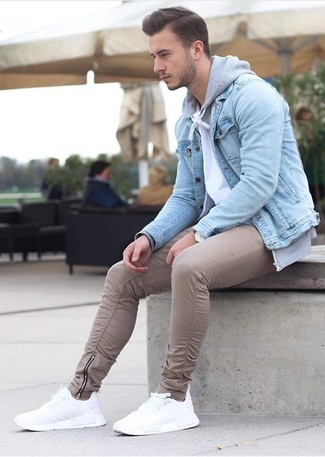 Как носить белые кроссовки с светло-коричневыми брюками чинос: Голубая джинсовая куртка и светло-коричневые брюки чинос — необходимые составляющие в гардеробе мужчин с чувством стиля. Белые кроссовки позволят сделать лук не таким формальным.
