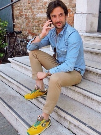 С чем носить желтые кроссовки мужчине в стиле кэжуал: Голубая джинсовая рубашка и светло-коричневые брюки чинос помогут создать гармоничный и модный образ. Если подобный ансамбль кажется тебе слишком смелым, уравновесь его желтыми кроссовками.