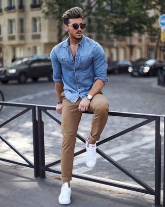 Как носить синюю джинсовую рубашку с белыми кожаными низкими кедами в 30 лет мужчине в теплую погоду: Синяя джинсовая рубашка и светло-коричневые брюки чинос прочно обосновались в гардеробе многих молодых людей, помогая создавать неповторимые и стильные образы. В тандеме с этим ансамблем наиболее уместно смотрятся белые кожаные низкие кеды.