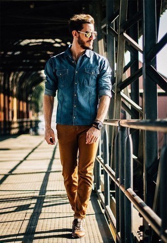 Как носить темно-синюю джинсовую рубашку с коричневыми брюками чинос лето: Комбо из темно-синей джинсовой рубашки и коричневых брюк чинос не прекращает нравиться стильным мужчинам. В паре с этим образом наиболее выгодно будут смотреться табачные кожаные низкие кеды. Как тебе такое сочетание вещей на жаркую летнюю погоду?