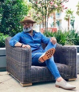 С чем носить джинсовую рубашку за 50 лет мужчине в теплую погоду в стиле смарт-кэжуал: Если ты ценишь комфорт и практичность, обрати внимание на дуэт джинсовой рубашки и синих джинсов. Если ты предпочитаешь смелые настроения в своих ансамблях, закончи этот серыми туфлями дерби из плотной ткани.