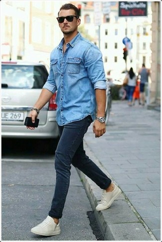 Какие джинсовые рубашки носить с синими зауженными джинсами мужчине лето в стиле кэжуал: Такое простое и комфортное сочетание вещей, как джинсовая рубашка и синие зауженные джинсы, полюбится мужчинам, которые любят проводить дни в постоянном движении. Бежевые низкие кеды органично дополнят этот образ. Переносить изнурительный летний зной будет определенно проще, когда на тебе такое сочетание одежды.