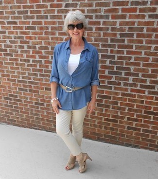 С чем носить темно-синюю джинсовую рубашку за 50 лет женщине в стиле смарт-кэжуал: Темно-синяя джинсовая рубашка и бежевые брюки чинос — необходимые предметы в гардеробе барышень с великолепным вкусом в одежде. Бежевые замшевые босоножки на каблуке — хороший вариант, чтобы закончить ансамбль.