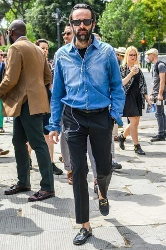 Как носить серые классические брюки с черными кожаными лоферами за 40 лет мужчине в теплую погоду в стиле смарт-кэжуал: Сочетание синей джинсовой рубашки и серых классических брюк — превосходный пример делового городского стиля. Теперь почему бы не привнести в этот лук на каждый день немного консерватизма с помощью черных кожаных лоферов?