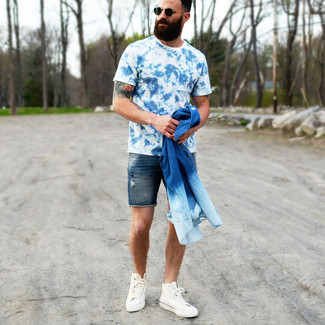 С чем носить темно-синие джинсовые шорты мужчине в теплую погоду: Сочетание синей джинсовой рубашки и темно-синих джинсовых шорт поможет создать стильный мужской ансамбль. Этот образ неплохо дополнят белые высокие кеды из плотной ткани.