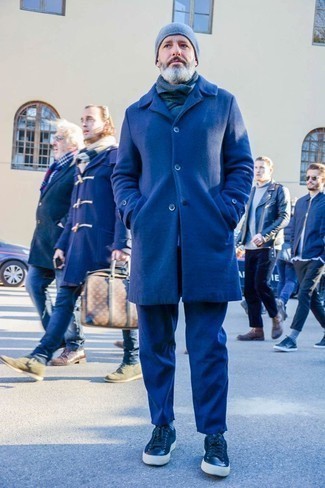 С чем носить синие кеды за 40 лет мужчине в холод в стиле смарт-кэжуал: Комбо из темно-синего длинного пальто и темно-синих брюк чинос — необычный образ для джентльменов, работающих в офисе. Если сочетание несочетаемого привлекает тебя не меньше, чем безвременная классика, дополни этот наряд синими кедами.