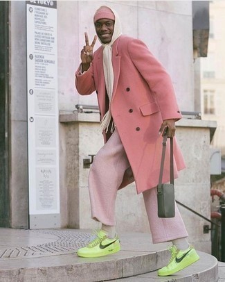 Модный лук: розовое длинное пальто, розовые брюки чинос, зелено-желтые кожаные низкие кеды, оливковая кожаная сумка почтальона