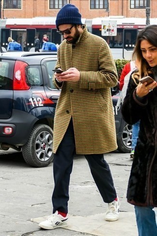 Модный мужской лук: светло-коричневое длинное пальто с узором "гусиные лапки", темно-синие брюки чинос, бело-черные низкие кеды из плотной ткани, темно-синяя шапка