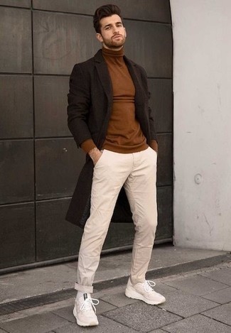 С чем носить светло-коричневые брюки чинос в прохладную погоду: Темно-коричневое длинное пальто и светло-коричневые брюки чинос будут прекрасно смотреться в модном гардеробе самых требовательных джентльменов. Ты можешь легко адаптировать такой ансамбль к повседневным делам, надев бежевыми кроссовками.