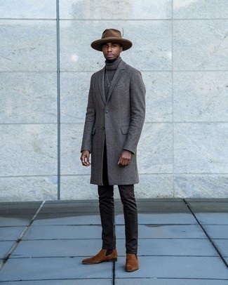 С чем носить темно-коричневую шерстяную шляпу мужчине в прохладную погоду: Такое простое и комфортное сочетание базовых вещей, как темно-серое длинное пальто и темно-коричневая шерстяная шляпа, придется по душе мужчинам, которые любят проводить дни в постоянном движении. Не прочь сделать ансамбль немного элегантнее? Тогда в качестве обуви к этому луку, стоит обратить внимание на коричневые замшевые ботинки челси.