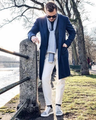 С чем носить темно-синее длинное пальто в 30 лет: Темно-синее длинное пальто и белые брюки чинос будут великолепно смотреться в модном гардеробе самых избирательных джентльменов. Чтобы образ не получился слишком претенциозным, можно дополнить его серыми низкими кедами из плотной ткани.