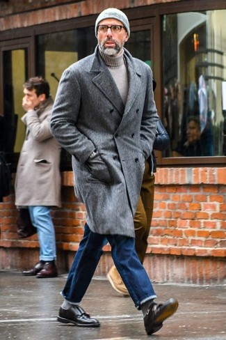 Как одеваться мужчине за 50 в холод: Образ из серого длинного пальто и синих джинсов смотрится очень выгодно, разве нет? Хотел бы сделать ансамбль немного элегантнее? Тогда в качестве обуви к этому образу, стоит выбрать черные кожаные монки с двумя ремешками.