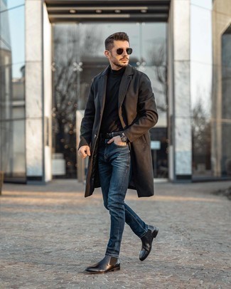 Как носить темно-коричневое длинное пальто с темно-синими зауженными джинсами в прохладную погоду: Темно-коричневое длинное пальто и темно-синие зауженные джинсы прочно закрепились в гардеробе современных мужчин, помогая создавать незаезженные и удобные образы. Хотел бы сделать ансамбль немного элегантнее? Тогда в качестве дополнения к этому образу, стоит обратить внимание на черные кожаные ботинки челси.