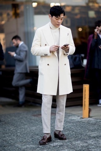 С чем носить белое длинное пальто в прохладную погоду: Белое длинное пальто смотрится великолепно в тандеме с серыми классическими брюками. Темно-красные кожаные лоферы с кисточками позволят сделать лук менее строгим.
