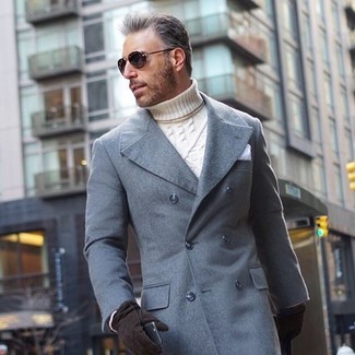 С чем носить бело-темно-синюю водолазку за 50 лет мужчине: Бело-темно-синяя водолазка в сочетании с серым длинным пальто прекрасно подойдет для офиса.