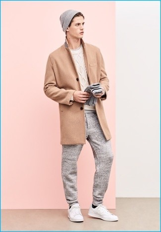 Модный лук: светло-коричневое длинное пальто, белый вязаный свитер, серая футболка с круглым вырезом, серые спортивные штаны