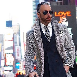 С чем носить серый галстук мужчине в прохладную погоду: Серое длинное пальто с узором "в ёлочку" в паре с серым галстуком — воплощение строгого делового стиля.