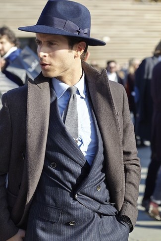 С чем носить синюю шерстяную шляпу мужчине в холод: Сочетание темно-коричневого длинного пальто и синей шерстяной шляпы - очень практично, и поэтому прекрасно подойдет для повседневой носки.