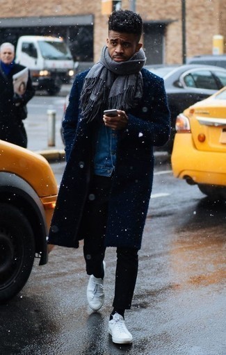 Как носить черные брюки чинос с синей джинсовой курткой в 30 лет в стиле смарт-кэжуал: Удобное сочетание синей джинсовой куртки и черных брюк чинос позволит подчеркнуть твой личный стиль и выгодно выделиться из общей массы. Если сочетание несочетаемого привлекает тебя не меньше, чем безвременная классика, дополни свой образ белыми кожаными низкими кедами.