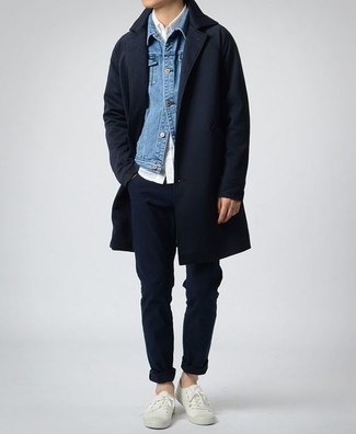 Как носить темно-синюю джинсовую куртку с темно-синим длинным пальто в прохладную погоду в стиле смарт-кэжуал: Тандем темно-синего длинного пальто и темно-синей джинсовой куртки позволит создать элегантный и современный мужской образ. Чтобы добавить в лук немного небрежности , на ноги можно надеть белые низкие кеды.