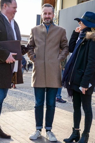 Как носить светло-коричневое длинное пальто с бело-темно-синими кожаными низкими кедами за 40 лет: Светло-коричневое длинное пальто и темно-синие джинсы великолепно впишутся в любой мужской образ — непринужденный повседневный образ или же утонченный вечерний. Ты можешь легко адаптировать такой образ к повседневным делам, завершив его бело-темно-синими кожаными низкими кедами.