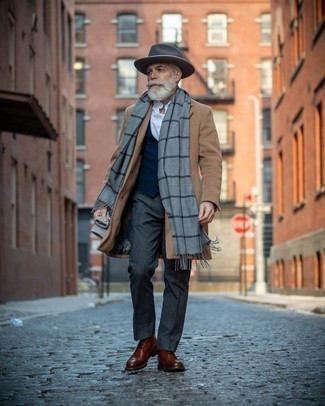 С чем носить темно-серую шерстяную шляпу за 50 лет мужчине в холод: Сочетание светло-коричневого длинного пальто и темно-серой шерстяной шляпы - очень практично, и поэтому идеально для создания беззаботного повседневного  образа. Не прочь сделать ансамбль немного строже? Тогда в качестве обуви к этому ансамблю, стоит обратить внимание на коричневые кожаные повседневные ботинки.