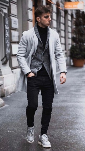 С чем носить черные зауженные джинсы мужчине в прохладную погоду: Попробуй сочетание серого длинного пальто и черных зауженных джинсов, и ты получишь стильный непринужденный мужской ансамбль, который подойдет на каждый день. Если сочетание несочетаемого привлекает тебя не меньше, чем проверенная классика, закончи свой ансамбль серыми кожаными низкими кедами.