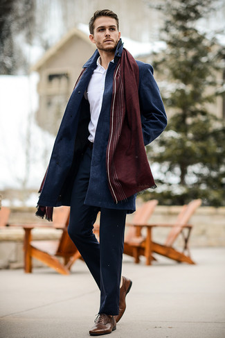 Как носить темно-синее длинное пальто с темно-синими брюками чинос в деловом стиле: Лук из темно-синего длинного пальто и темно-синих брюк чинос смотрится бесподобно, разве не так? Очень недурно здесь выглядят коричневые кожаные оксфорды.