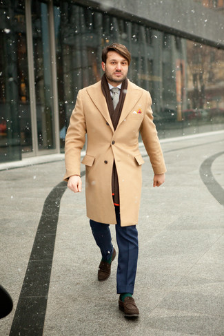 С чем носить серый галстук мужчине в прохладную погоду: Сочетание светло-коричневого длинного пальто и серого галстука — прекрасный пример делового городского стиля. Завершив лук темно-коричневыми замшевыми лоферами, можно привнести в него немного беззаботства.
