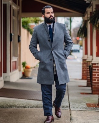 С чем носить серое длинное пальто: Сочетание серого длинного пальто и темно-синих классических брюк поможет создать стильный классический лук. В тандеме с этим ансамблем прекрасно будут смотреться темно-красные кожаные оксфорды.