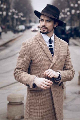 С чем носить темно-коричневую шляпу мужчине в прохладную погоду: Для активного дня в компании друзей идеально подойдет сочетание светло-коричневого длинного пальто и темно-коричневой шляпы.
