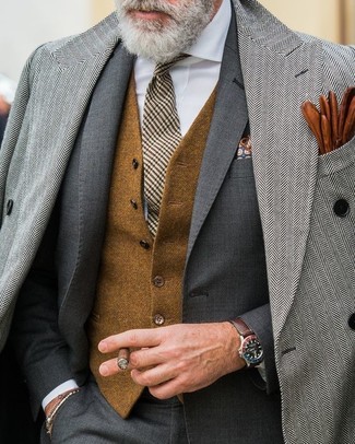 Модный лук: серое длинное пальто с узором "в ёлочку", темно-серый костюм, коричневый шерстяной жилет, белая классическая рубашка