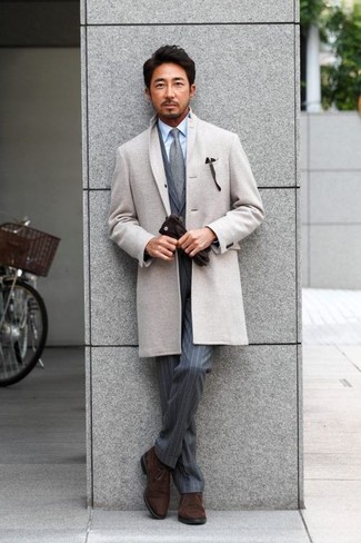 Модный лук: серое длинное пальто, серый костюм в вертикальную полоску, голубая классическая рубашка, темно-коричневые замшевые ботинки дезерты
