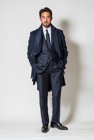Как носить длинное пальто с монками с двумя ремешками: Сочетание длинного пальто и темно-синего костюма в вертикальную полоску поможет создать выразительный мужской лук. Весьма выигрышно здесь смотрятся монки с двумя ремешками.