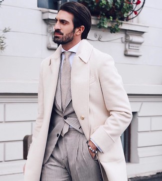 С чем носить серый браслет в 30 лет мужчине в деловом стиле: Если день обещает быть суматошным, сочетание бежевого длинного пальто и серого браслета позволит создать удобный образ в непринужденном стиле.
