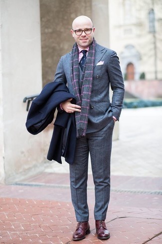 С чем носить темно-серый шарф в 30 лет мужчине в деловом стиле: Если в одежде ты ценишь удобство и практичность, темно-синее длинное пальто и темно-серый шарф — прекрасный вариант для модного повседневного мужского образа. Хочешь привнести сюда толику строгости? Тогда в качестве обуви к этому ансамблю, обрати внимание на темно-красные кожаные повседневные ботинки.