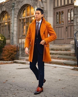 С чем носить оранжевое длинное пальто в прохладную погоду в деловом стиле: Несмотря на то, что это классический лук, сочетание оранжевого длинного пальто и темно-синего вельветового костюма неизменно нравится стильным мужчинам, а также пленяет дамские сердца. Такой лук несложно приспособить к повседневным делам, если надеть в паре с ним табачные кожаные монки с двумя ремешками.