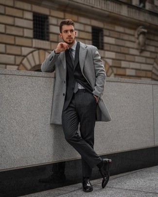 С чем носить темно-серый галстук в шотландскую клетку мужчине в деловом стиле: Сочетание серого длинного пальто и темно-серого галстука в шотландскую клетку поможет составить эффектный мужской лук. Что же до обуви, можно закончить лук черными кожаными оксфордами.