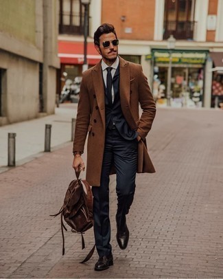С чем носить темно-коричневый кожаный рюкзак мужчине в деловом стиле: Если ты ценишь комфорт и функциональность, коричневое длинное пальто и темно-коричневый кожаный рюкзак — великолепный выбор для стильного мужского ансамбля на каждый день. Этот образ обретет новое прочтение в паре с темно-коричневыми кожаными туфлями дерби.