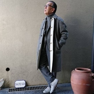 С чем носить серый свитер за 60 лет мужчине в холод в стиле смарт-кэжуал: Серый свитер в сочетании с темно-серыми классическими брюками — замечательный пример строгого делового стиля. Серые низкие кеды из плотной ткани чудесно впишутся в образ.