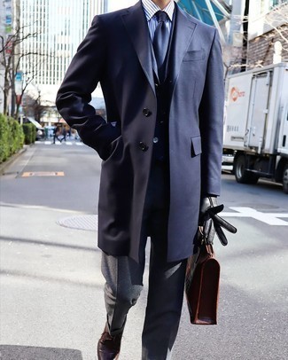 Как носить темно-серые классические брюки с коричневыми кожаными туфлями дерби в прохладную погоду в деловом стиле: Темно-синее длинное пальто в паре с темно-серыми классическими брюками позволит создать запоминающийся мужской лук. Если сочетание несочетаемого привлекает тебя не меньше, чем проверенная классика, дополни свой наряд коричневыми кожаными туфлями дерби.