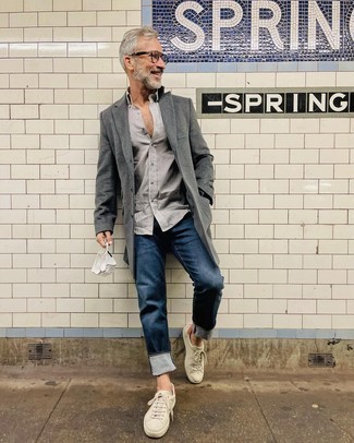С чем носить кожаные кеды мужчине: Дуэт серого длинного пальто и темно-синих джинсов позволит выглядеть стильно, но при этом подчеркнуть твой индивидуальный стиль. Дополнив ансамбль кожаными кедами, ты привнесешь в него динамичность.