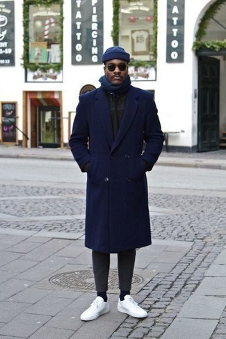 С чем носить темно-синюю шапку мужчине: Сочетание темно-синего длинного пальто и темно-синей шапки пользуется особой популярностью среди ценителей удобной одежды. Идеально сюда подходят белые низкие кеды из плотной ткани.