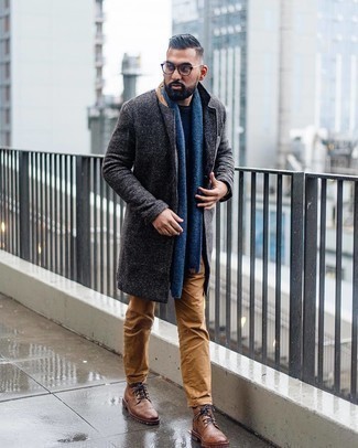 Модный лук: темно-серое длинное пальто, темно-синий свитер с круглым вырезом, светло-коричневые брюки чинос, коричневые кожаные повседневные ботинки