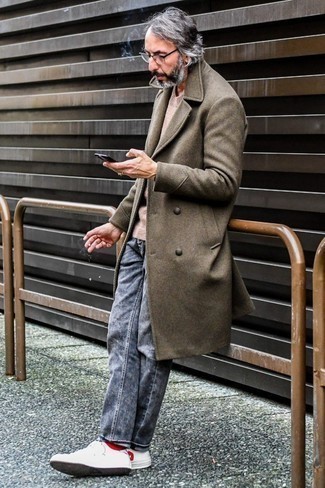 Как носить темно-серые джинсы с бело-черными кожаными низкими кедами мужчине в прохладную погоду в стиле смарт-кэжуал: Тандем коричневого длинного пальто и темно-серых джинсов поможет выглядеть аккуратно, а также выразить твою индивидуальность. Ты сможешь легко приспособить такой образ к повседневным нуждам, завершив его бело-черными кожаными низкими кедами.